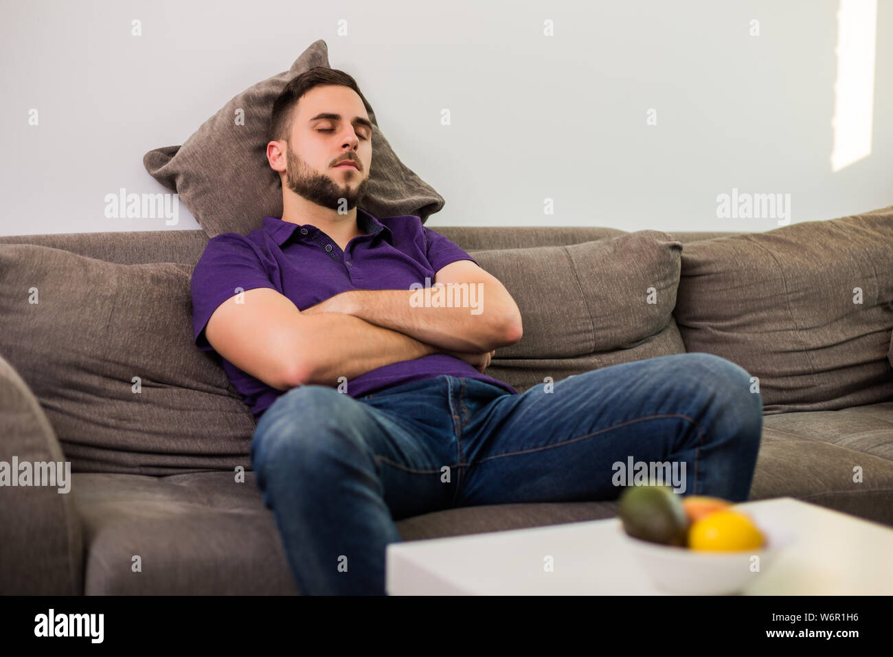 L Homme S Endormit Tandis Que Assis Sur Un Canapé Dans Son Salon Photo Stock Alamy